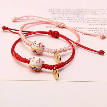 Two Enchanting Lucky Cat Charm Bracelets by KittyNook Cat Co., pink and red, with gold Maneki-neko charms.